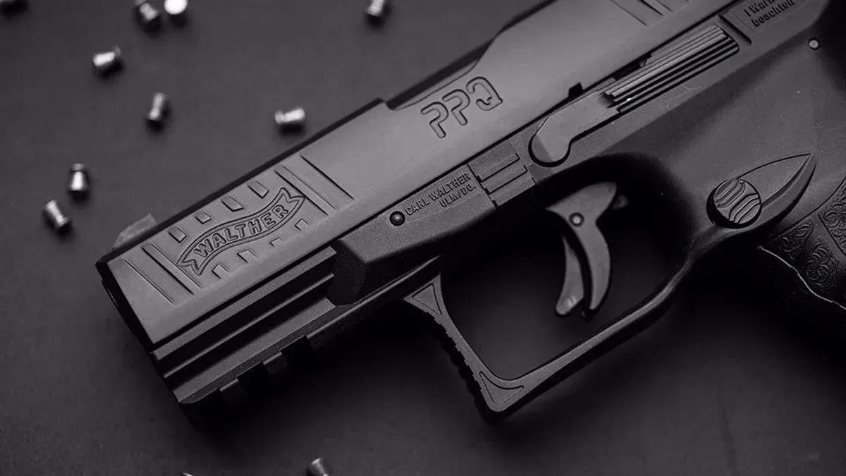 Svart luftpistol i närbild med diabolos utspridda på ett bord