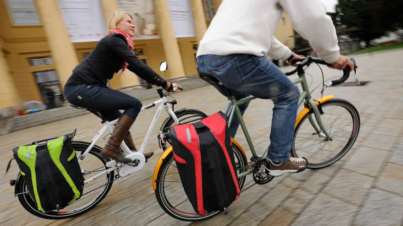 Två packade cykelväskor monterade på pakethållaren på en cykel