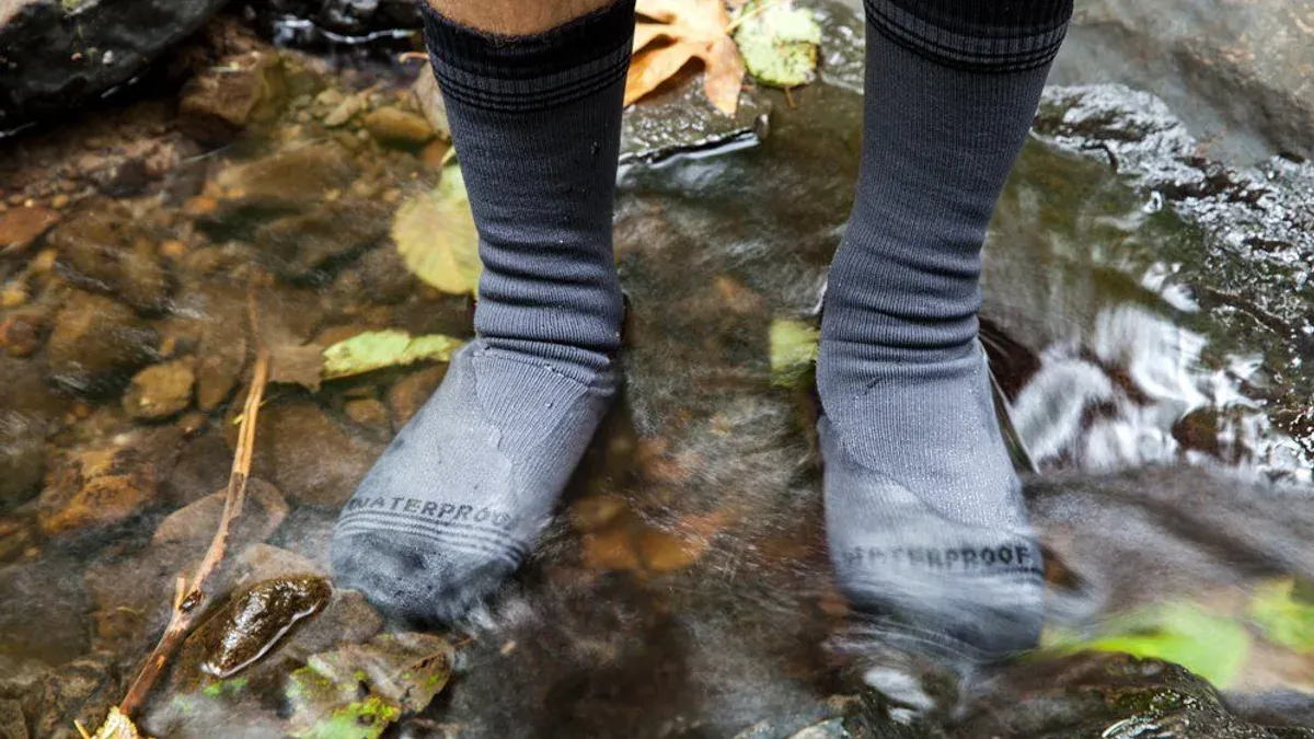 Fötter i grå strumpor märkta waterproof i bäck