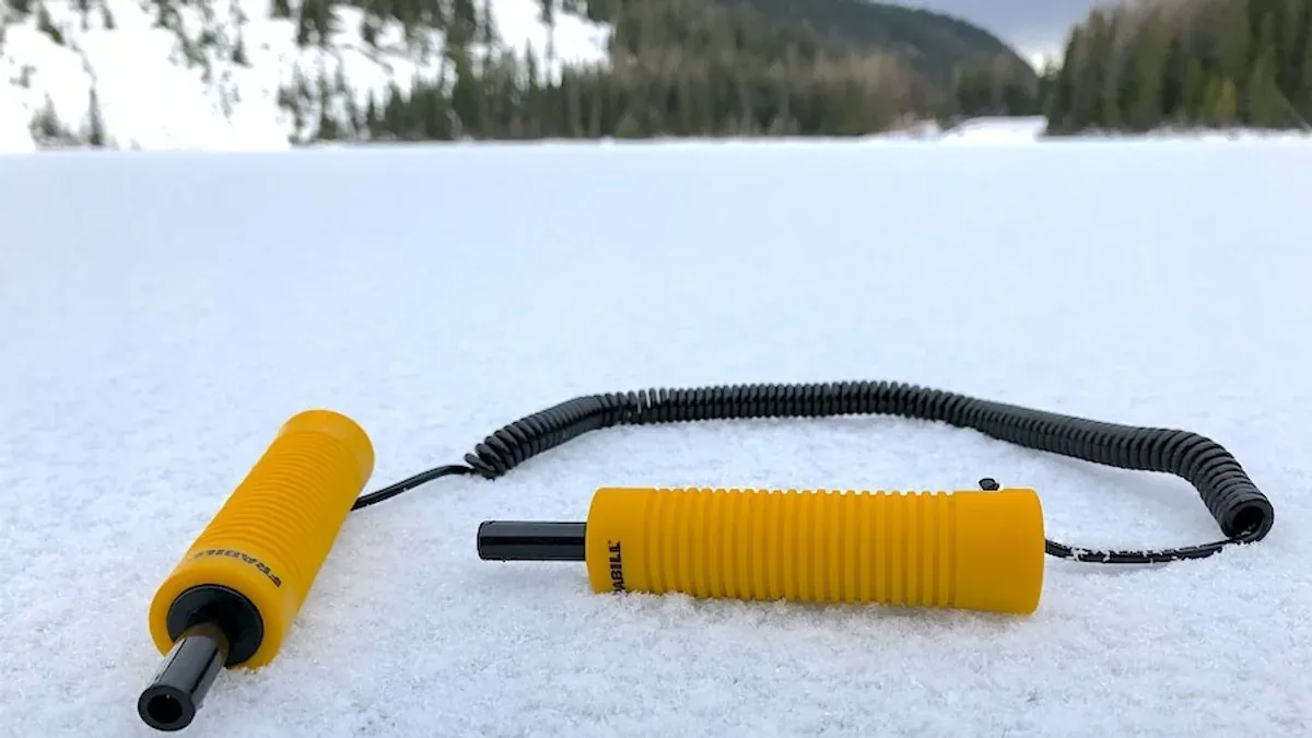 Gula isdubbar kopplade med spiralsnöre i snö
