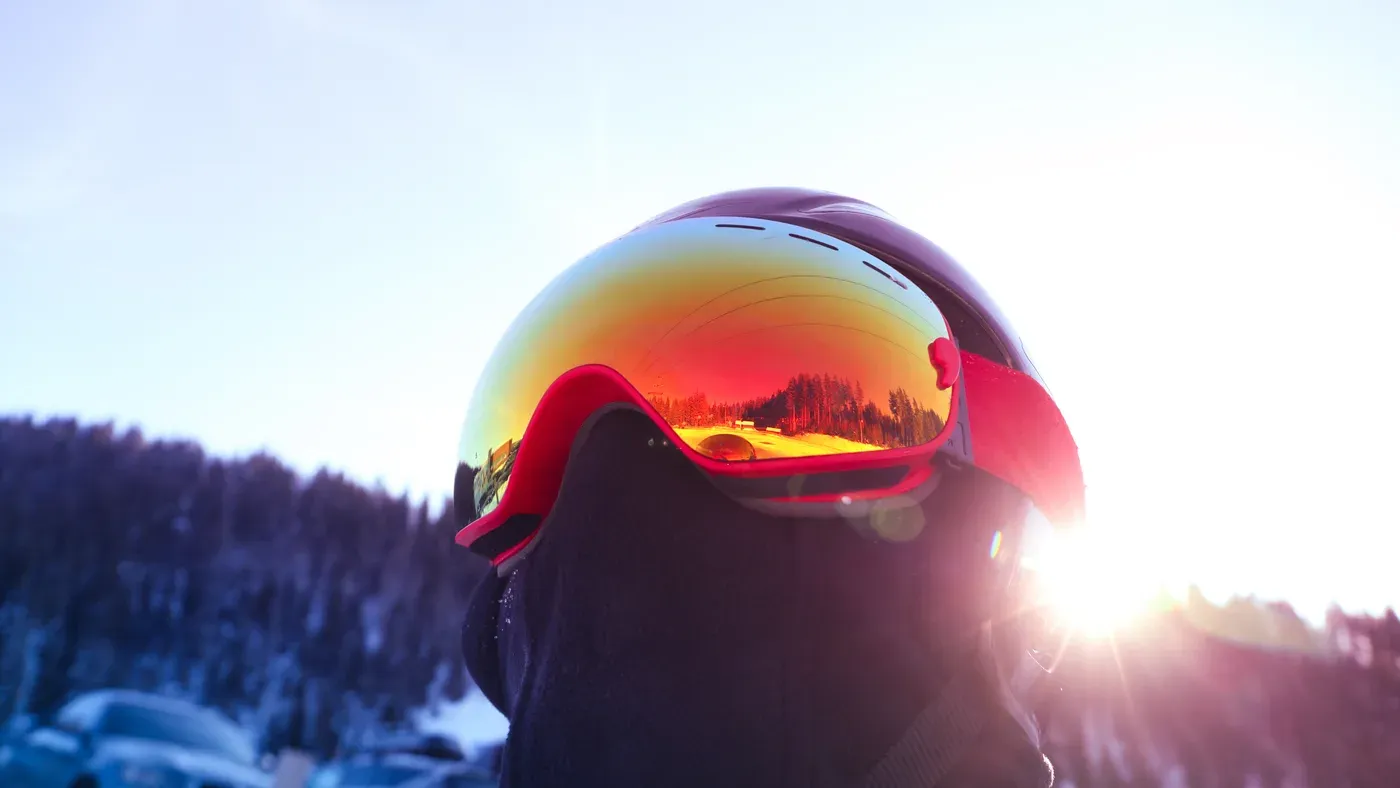 Skidhjälm med orangespegel-visir i motljus vid solnedgång