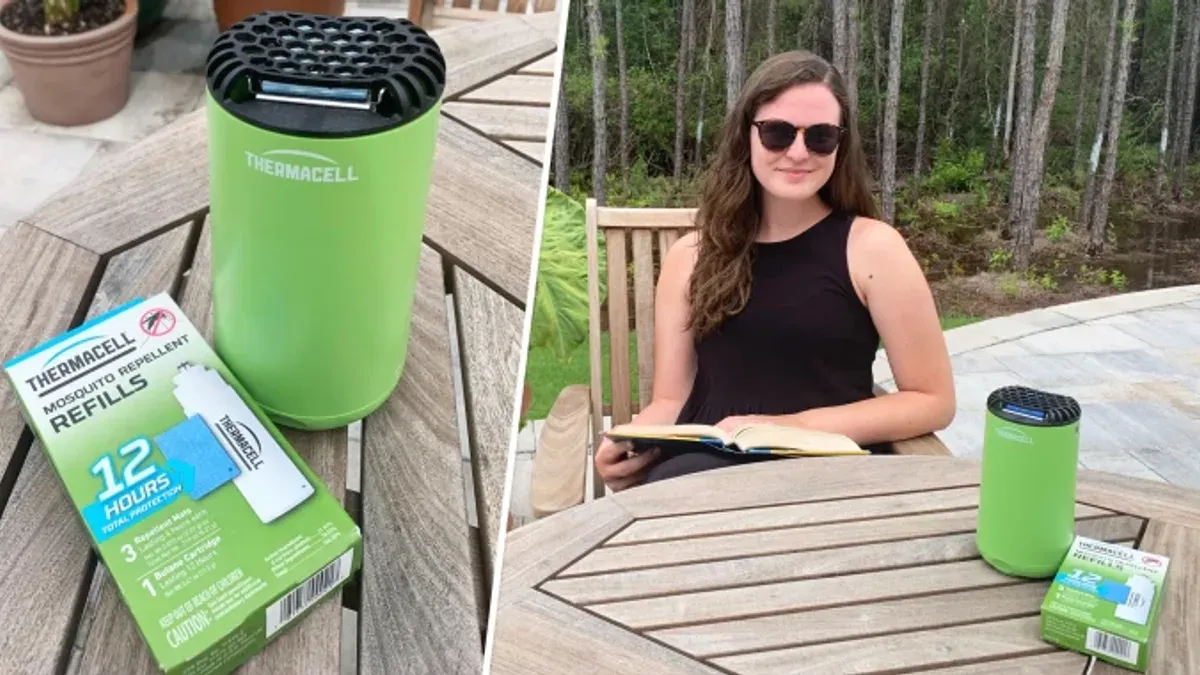 Grön myggskyddsapparat på trädgårdsbord bredvid kvinna som läser