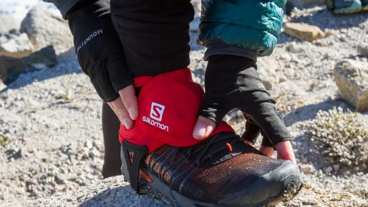 Röd Salomon-gamage spänns fast runt en löparsko