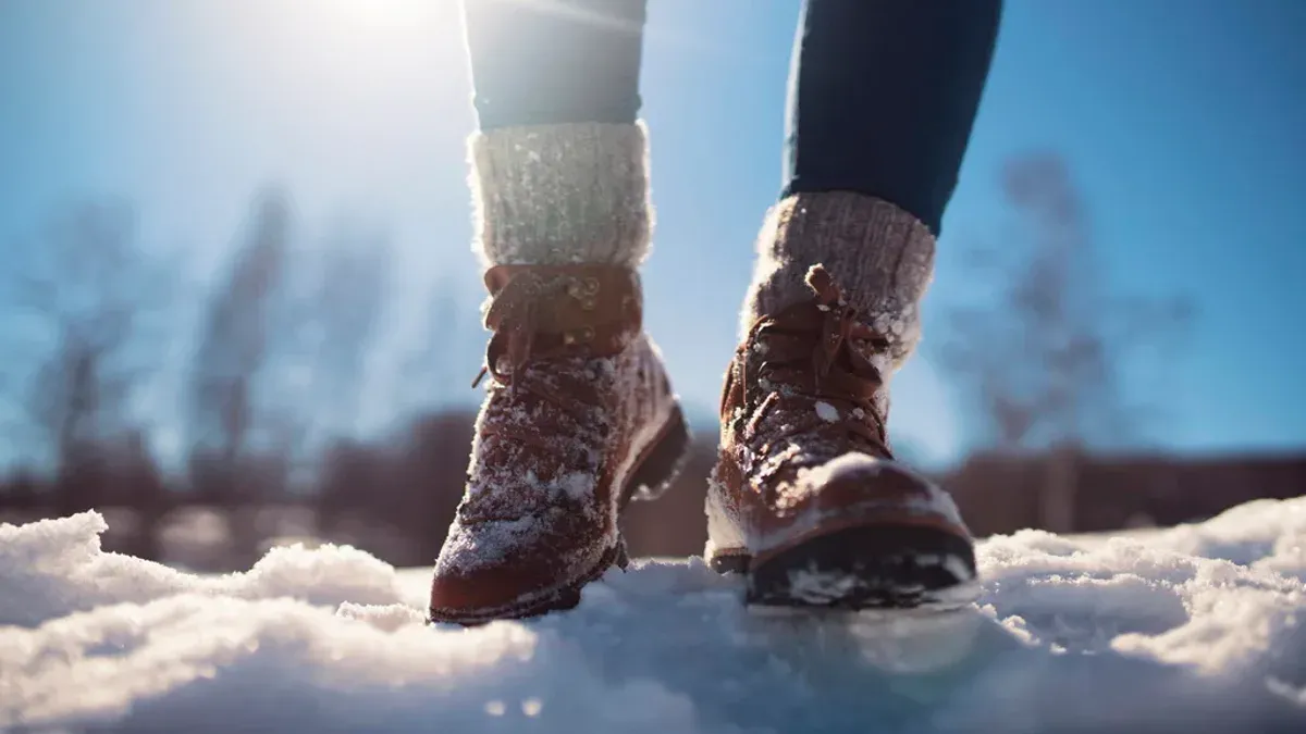 Person i vinterkängor med varma sockor i snö