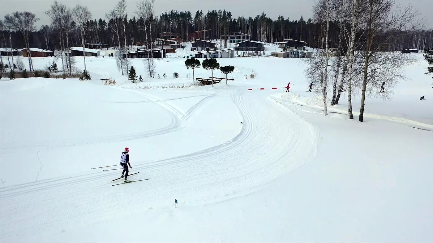 Längdskidåkare på preparerat spår vid stugby uppifrån