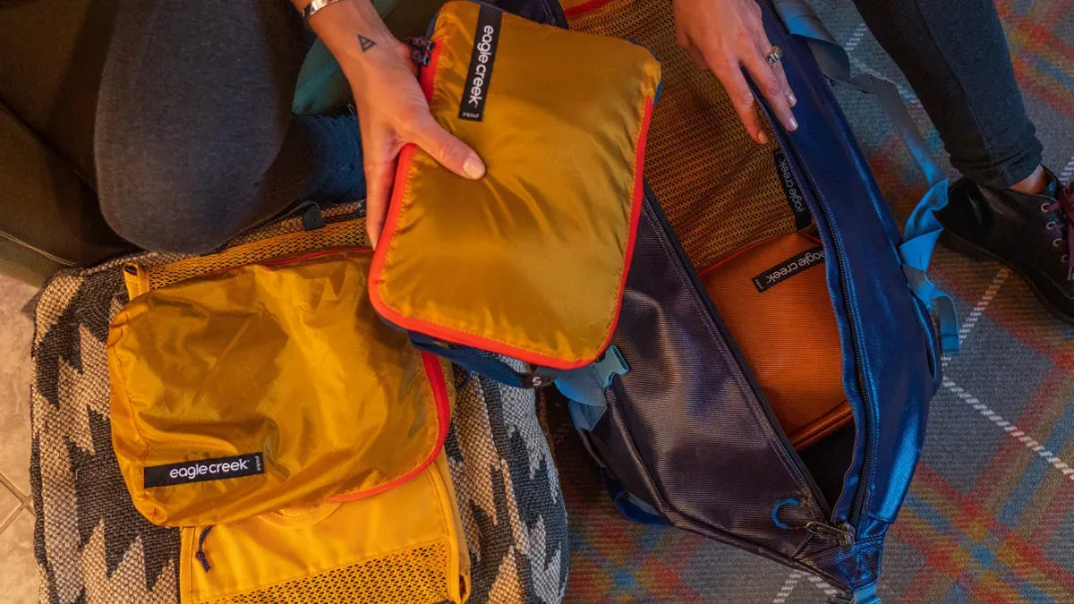 Flera packpåsar i gult och blått med Eagle Creek-logotyp