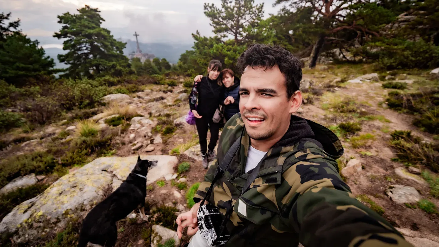 Grupp vandrare med hund tar en selfie på klippig stig